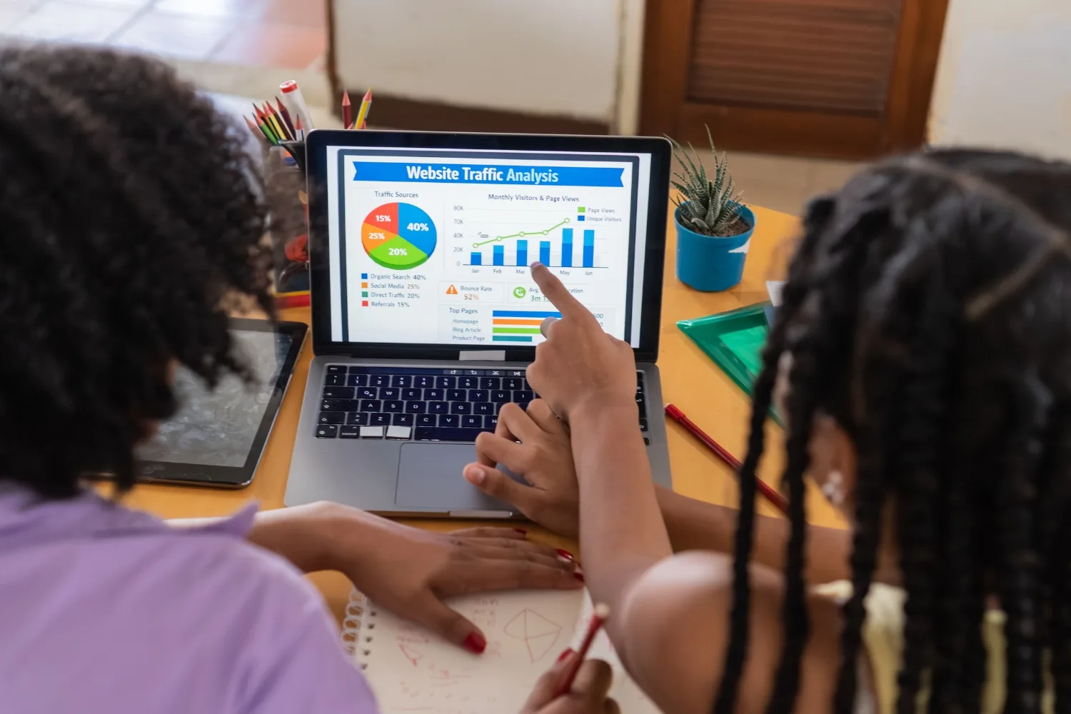 Person pointing at website traffic analysis data on a laptop screen during a technical audit.