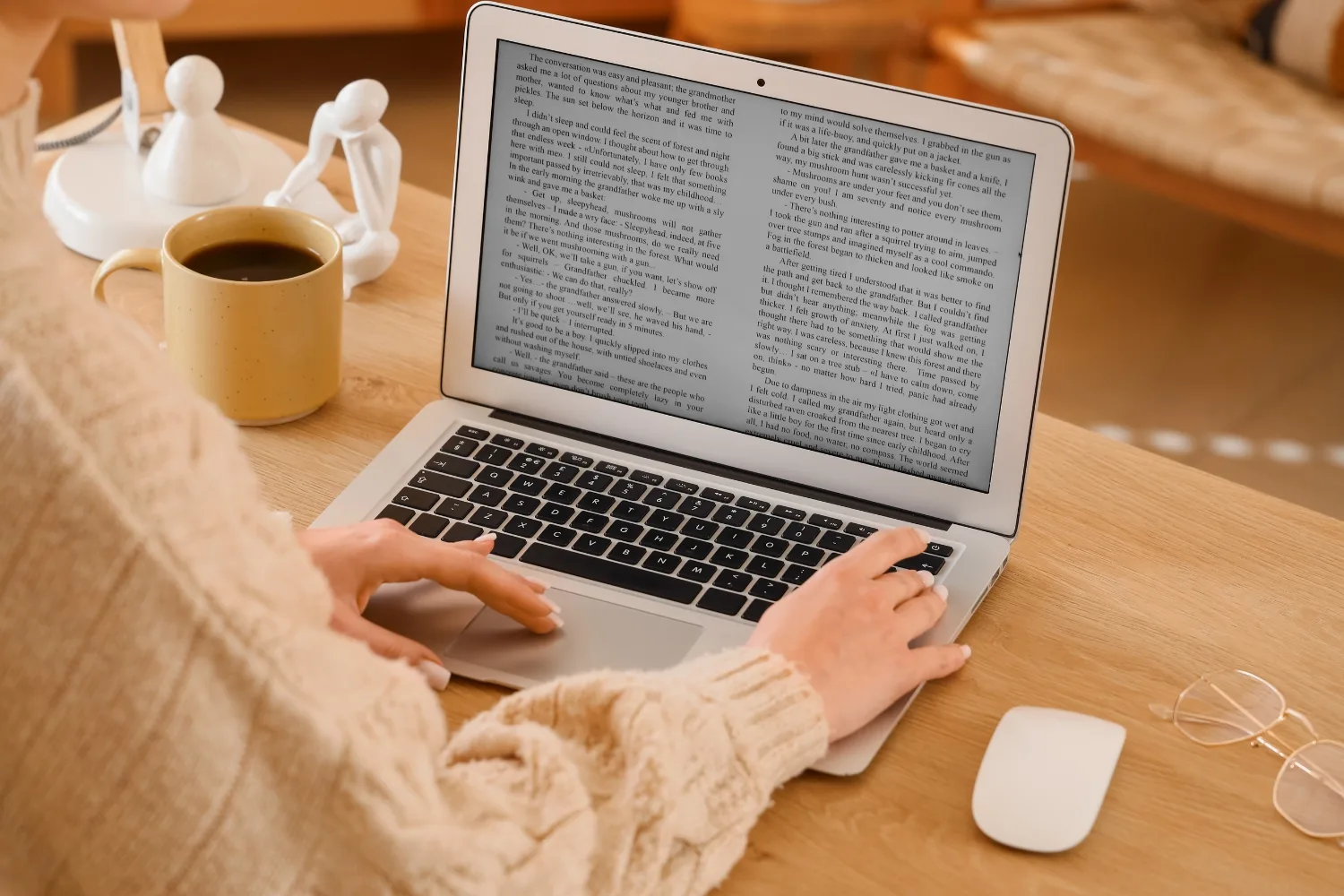 An Australian small business owner writing a blog post on a laptop at a tidy desk, with a notebook and coffee beside them, representing the practical reality of maintaining a business blog